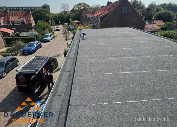 Nieuw bitumen plat dak met uitzicht over woonwijk in Twente