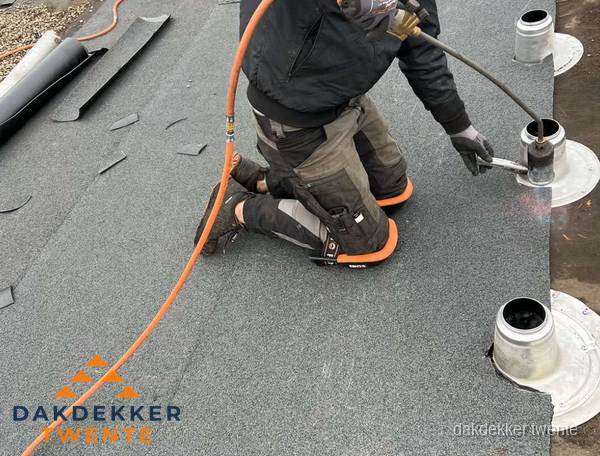 Dakdekker repareert bitumen dakleer bij dakdoorvoer in Twente Dakdekker repareert bitumen dakleer bij dakdoorvoer in Twente