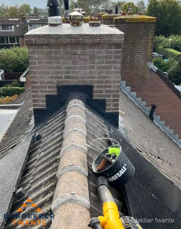 Schoorsteen met loodaansluiting en nokvorst op pannendak in Twente Schoorsteen met loodaansluiting en nokvorst op pannendak in Twente