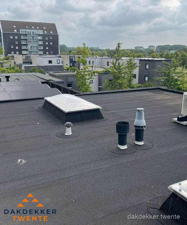 Groot plat dak met lichtkoepel en dakdoorvoeren in Twente