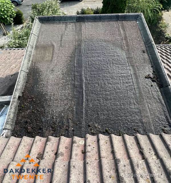 Verouderd plat dak met bitumen en slijtage voor lekkage inspectie in Twente Verouderd plat dak met bitumen en slijtage voor lekkage inspectie in Twente