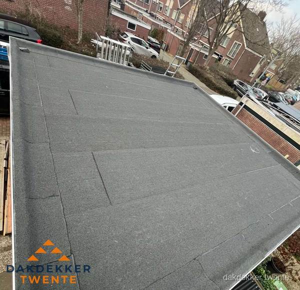 Nieuwe bitumen dakbedekking op plat dak van garage in Twente