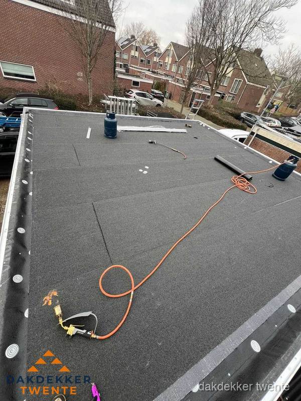 Afgewerkte dakrenovatie met bitumen op plat dak in Twente