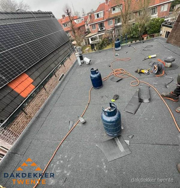 Daklekkage repareren met brandgereedschap op plat dak in Twente