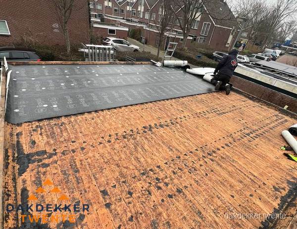 Dakdekker legt onderlaag op plat dak met houten constructie in Twente