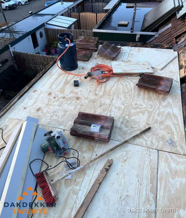 Dakreparatie werkzaamheden op plat dak met gereedschap in Twente