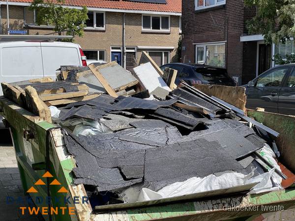 Afvalcontainer met gesloopt dakmateriaal tijdens dakkapel renovatie in Twente