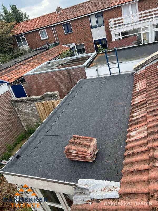 Aanbouw plat dak met reservepannen voor dakpannen vervangen in Twente