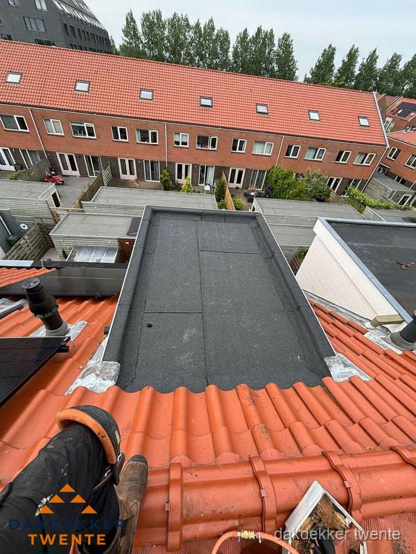 Bitumen dak reparatie op plat dak tussen dakpannen in Twente