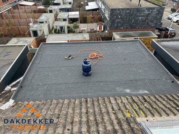 Plat dak met nieuwe bitumen dakbedekking en brandgereedschap in Twente
