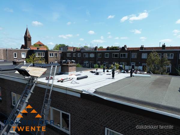 Dakdekkers aan het werk op plat dak in Twente